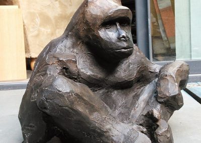 gorille-assis-tailleur-patine-claire-sourcils-froncés-leader-naturel-pause-sculpture-singe-chris-telque-france-lille-groupe-leading-bronze-animal